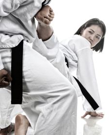 woman in white suit and black belt kicking